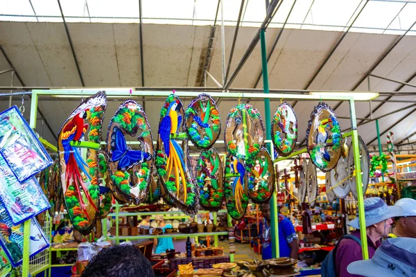 Puerto Limon, Costa Rica - 8 december 2019: Etniska souvenirer, basebollkepsar, väskor med olika mönster hängande på gatumarknaden — Stockfoto