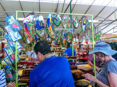 Puerto Limon, Kosta Rika - 8 Aralık 2019: Etnik hediyelik eşyalar, beyzbol şapkaları, sokak pazarında asılı çeşitli desenli çantalar