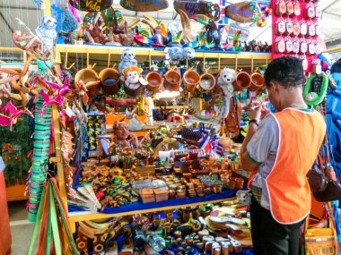 Puerto Limon, Kosta Rika - 8 Aralık 2019: Etnik hediyelik eşyalar, beyzbol şapkaları, sokak pazarında asılı çeşitli desenli çantalar