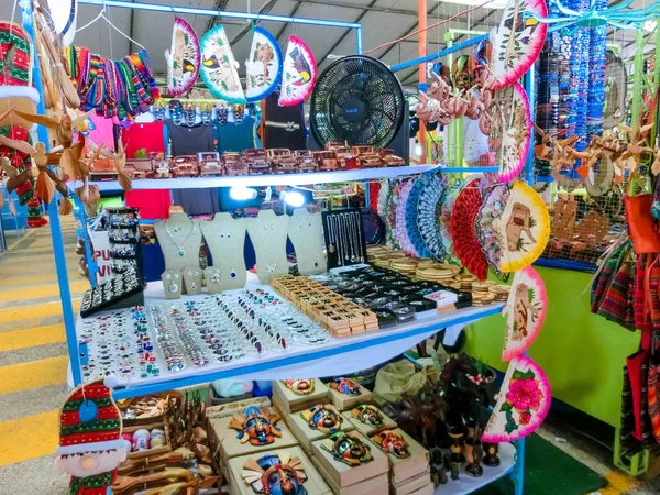 Пуэрто-Лимон, Коста-Рика - 8 декабря 2019 года: этнические сувениры, бейсболки, сумки с различными рисунками висят на уличном рынке — стоковое фото