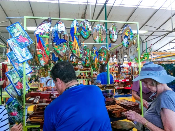 Puerto Limon, Kosta Rika - 8 Aralık 2019: Etnik hediyelik eşyalar, beyzbol şapkaları, sokak pazarında asılı çeşitli desenli çantalar