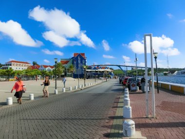 Willemstad, Curacao, Netherlands - December 5, 2019: People going near Queen Juliana Bridge Over Curacao. The Island Curacao is a tropical paradise in the Antilles in the Caribbean sea with beautiful architecture, beaches.