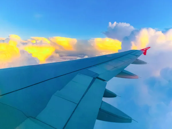 青い空と白い雲の上の飛行機からの眺め 飛行機に乗って飛んでいる 空の雲の上を飛んで飛行機の翼 楕円形の窓 イルミネーター — ストック写真