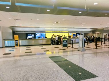 Miami, Florida, USA - November 29, 2019: The people near Hertz rental car office at Miami airport at Miami, Florida, USA