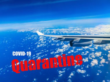 Bulutların üzerinde uçan bir uçağın kanat görüntüsü. Bir uçak penceresinden bulutlar ve mavi gökyüzü. Covid-19 için Coronavirus işareti kavramı,