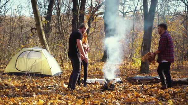 Turisté dělají táborák v podzimním lese — Stock video