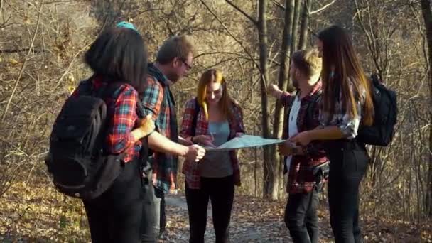 Bir grup yürüyüşçü sonbahar ormanlarında haritaya bakıyor. — Stok video