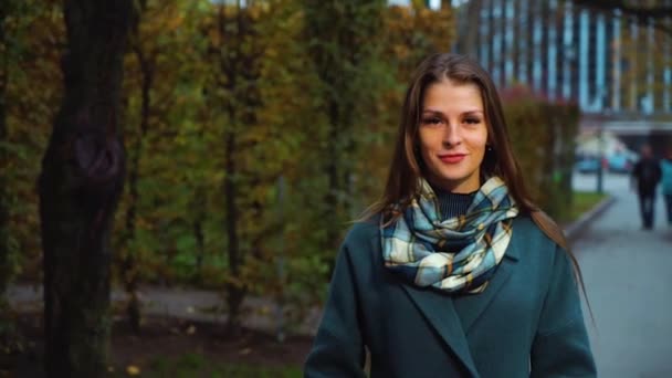 Pretty girl wearing coat walking in autumn park — Stock Video