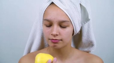 Banyo havlusuyla elma yiyen mutlu genç kız.