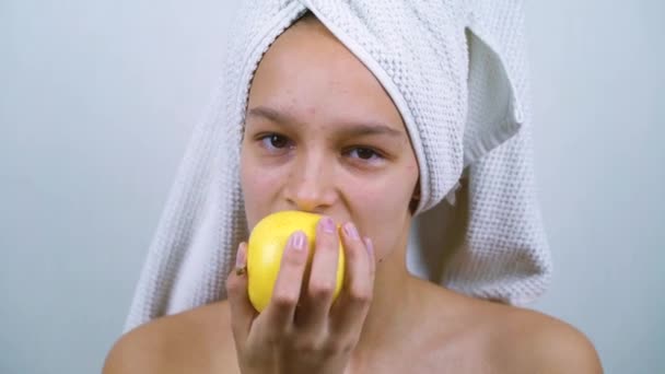 Puberty girl with bath towel on head having healthy snack — Stock Video