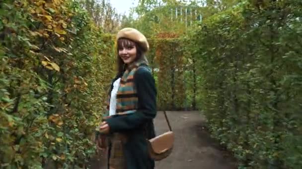 Милая девушка проводит время в садовом лабиринте осенью — стоковое видео