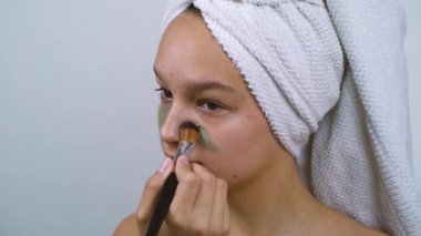 Cilt sorunu olan genç bir kız. Kaplıcada kilden maske takıyor.