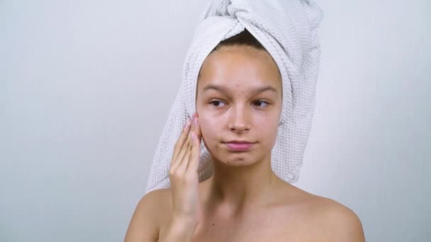 Bastante adolescente con acné aplicando crema facial después del baño — Vídeo de stock