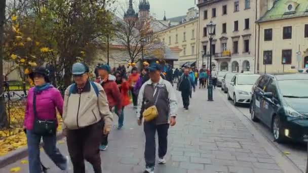 Krakow, Polen - Nov 16, 2019: äldre asiatiska turister går på gatan — Stockvideo