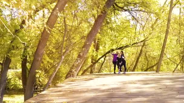 Chicas en forma feliz tomando foto selfie después de correr en el jardín de otoño — Vídeos de Stock