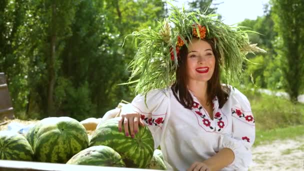 Liebenswertes weibliches Model posiert in Tracht neben Wassermelonen — Stockvideo