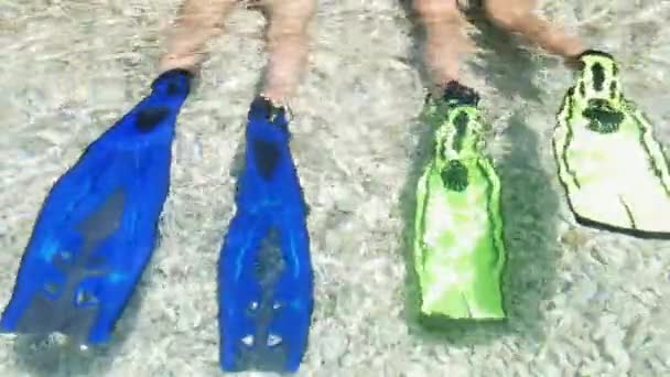 Några dykare med flippers som kopplar av på stranden — Stockvideo