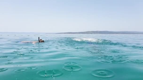 Casal feliz snorkeling com máscaras e nadadeiras perto de bóias do mar — Vídeo de Stock