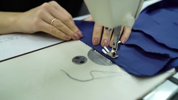 Hands of seamstress sewing pieces of blue fabric in fashion atelier — Stock Video