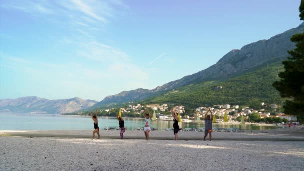 Baska Voda, Croácia - 12 de jun de 2019: atletas praticando ioga junto ao mar — Vídeo de Stock