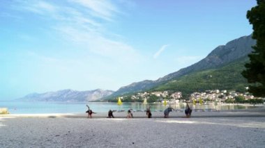 Mutlu arkadaşlar güzel deniz kenarında yoga yapıyor.