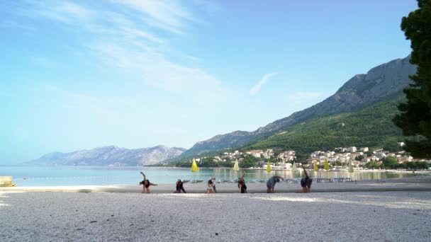 Happy friends berlatih yoga di tepi pantai yang indah — Stok Video