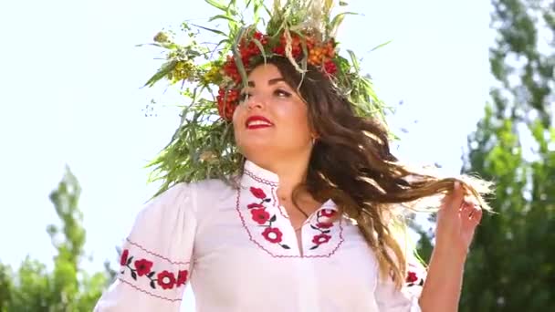 Amiable plus size model in bloemencirkel en versierde jurk poseren buiten — Stockvideo