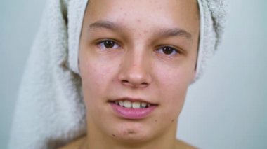 Kafasında banyo havlusu olan kahverengi gözlü güzel bir genç kız.