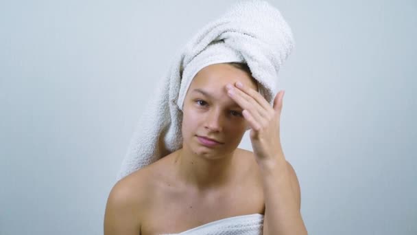 Adolescente amável envolto em toalhas examinando seu rosto com acne — Vídeo de Stock