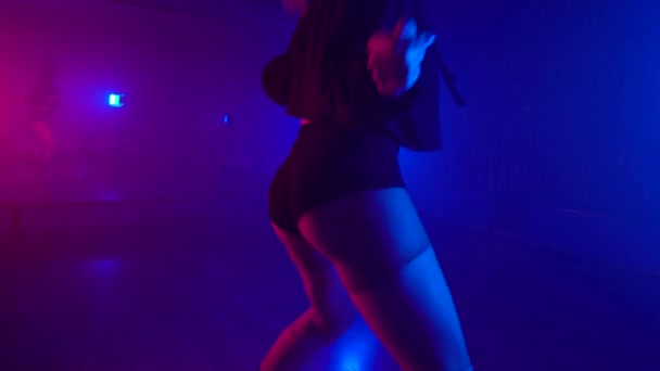 Belle fille dansant twerk dans le studio sombre avec miroir et lampes de poche — Video