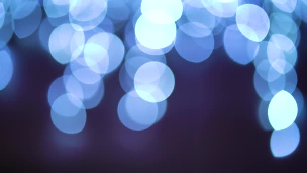 Círculos de luz azul bokeh revolviendo sobre fondo negro — Vídeo de stock