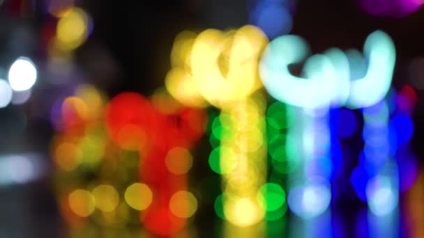 Kleurrijke bokeh lichten van feestelijke ornamenten op donkere achtergrond — Stockvideo