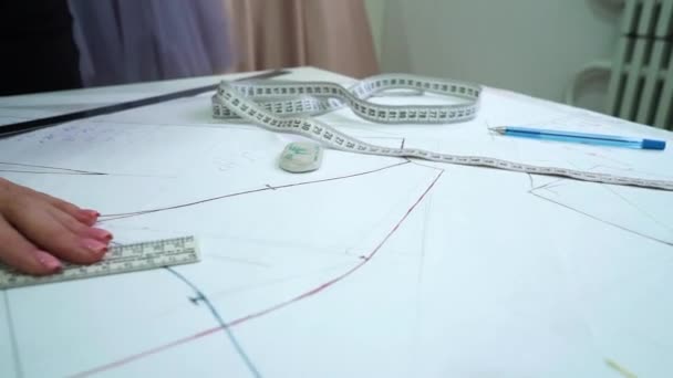 Mãos femininas desenho padrão de costura em papel no atelier costureiro — Vídeo de Stock