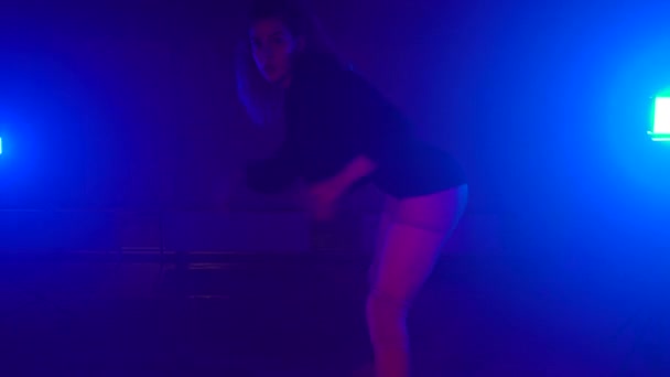 Danse sensuelle du butin réalisée par une fille blonde dans un studio sombre avec des lampes de poche — Video