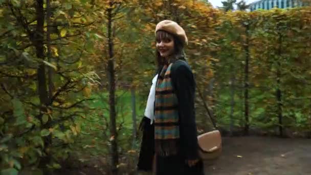 Happy girl in elegant outfit wandering in garden maze in autumn — Stock Video