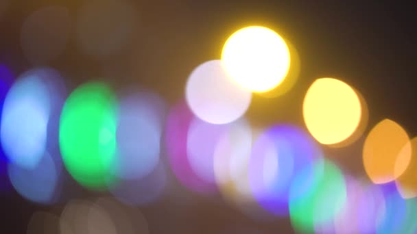 Luces festivas coloridas desenfocadas sobre fondo oscuro — Vídeo de stock