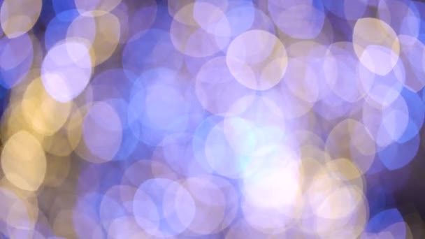 Bokeh luzes douradas e azuis de decorações festivas em movimento no fundo escuro — Vídeo de Stock
