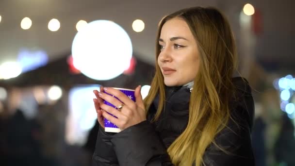 Girl drinking hot mulled wine on holiday market in winter — Stock Video