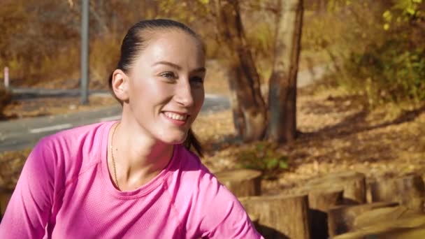 Красива усміхнена дівчина розтягується в осінньому парку — стокове відео