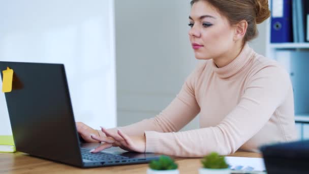 Menina positiva digitando no laptop no escritório — Vídeo de Stock