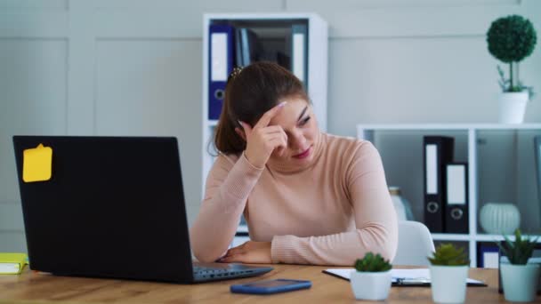 Sad girl typing on laptop in modern office — Stok video