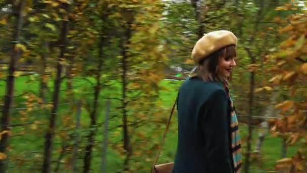 Chica alegre en traje elegante caminando en laberinto de jardín en otoño — Vídeo de stock