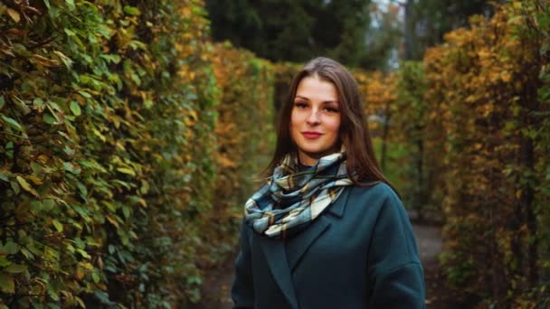 Gyönyörű lány pózol kerti labirintusban ősszel — Stock videók