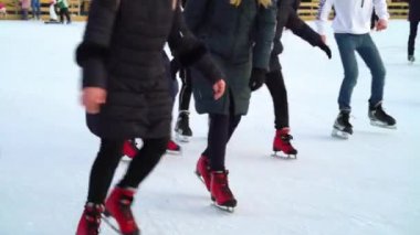 Families and friends enjoying skating on ice rink in winter