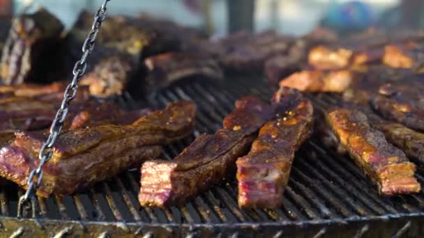 Grelhar costelas de porco suculentas no festival de comida de rua — Vídeo de Stock