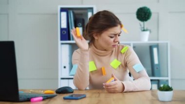 Ofiste yüzüne ve kıyafetlerine renkli çıkartmalar yapıştırılmış stresli bir kız.