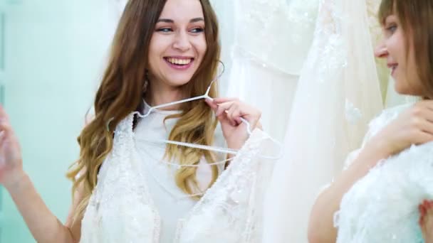 Ragazze allegre che provano abiti da sposa nel salone — Video Stock