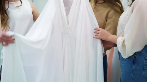 Meninas jovens em uso casual assistindo vestido elegante branco no salão de noivas — Vídeo de Stock