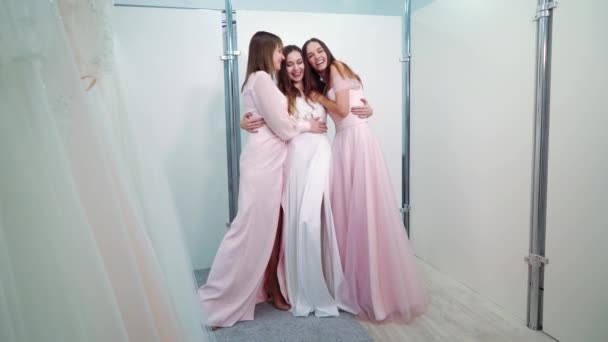 Joyful bride embracing bridesmaids in wedding salon — Stock video