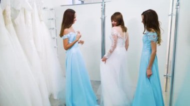 Mutlu gelin ve nedimeler salonda düğün töreni için elbiseler içinde dönüyorlar.